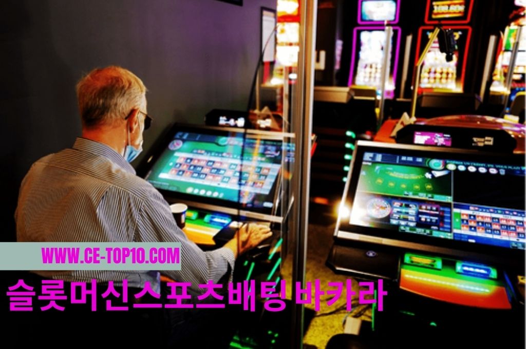 Old man sitting and playing alone at slot machine 